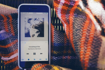 CDiPhone setup showing CD collection next to iPhone with music transfer workflow and external CD drive connection