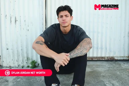 Dylan Jordan Net Worth article portrait of a man seated in black clothes against a white corrugated metal wall