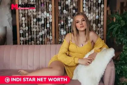 Indi Star in a yellow off-shoulder dress reclining on a pink couch for the Indi Star net worth article.