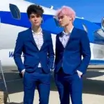 Stokes Twins Net Worth shown through Alan and Alex Stokes in blue suits standing in front of private jet