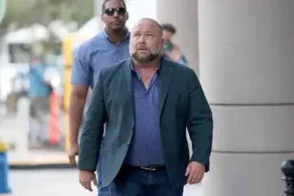 Alex Jones walking outside courthouse discussing net worth and bankruptcy proceedings in 2025