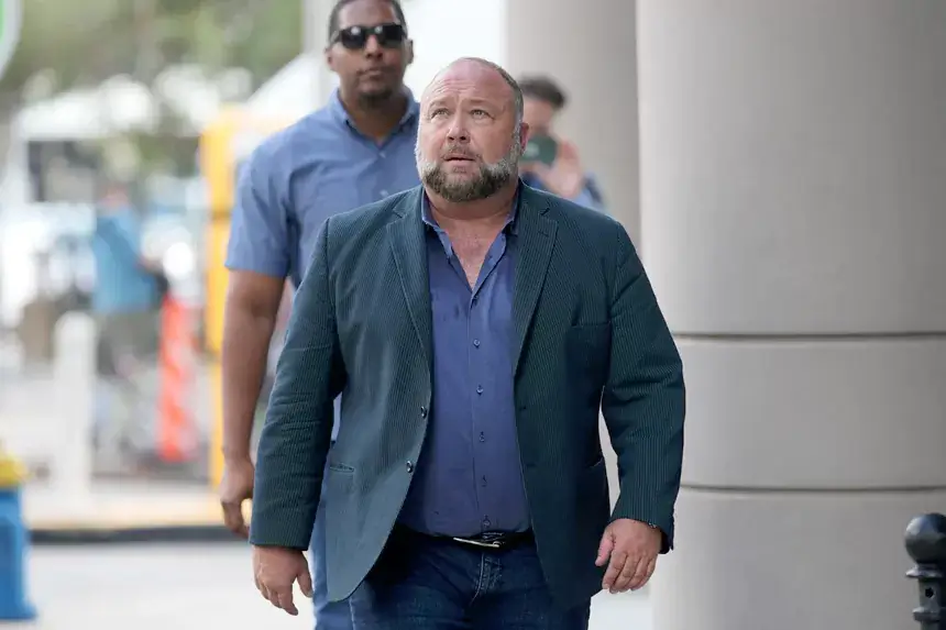 Alex Jones walking outside courthouse discussing net worth and bankruptcy proceedings in 2025
