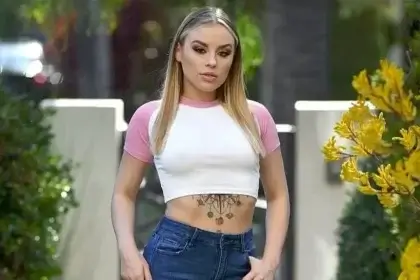 Anna Claire Clouds wearing white crop top and jeans showing her net worth success in 2025