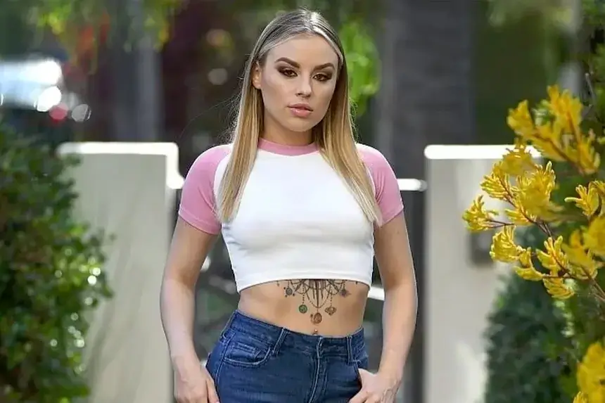 Anna Claire Clouds wearing white crop top and jeans showing her net worth success in 2025