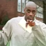 Anthony Mason pointing while wearing a plaid jacket during his NBA career representing his net worth and basketball legacy