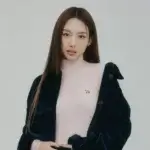 Nayeon in a pink turtleneck and navy coat, representing her brand image tied to her net worth profile