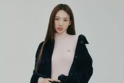 Nayeon in a pink turtleneck and navy coat, representing her brand image tied to her net worth profile