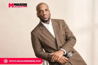 Ali Siddiq net worth profile - Houston stand-up comedian seated in brown suit holding microphone