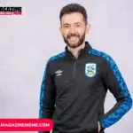 Carlos Corberán smiling in Huddersfield Town training jacket, studio headshot