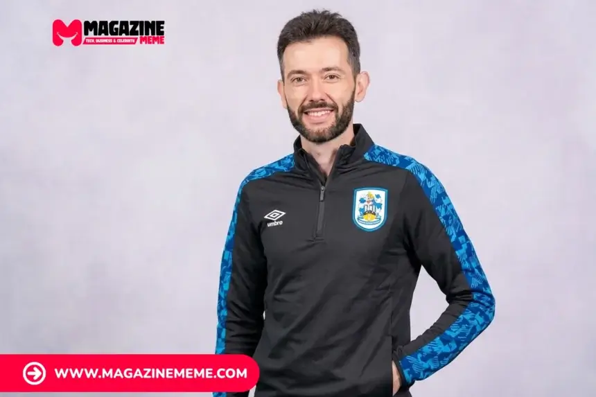 Carlos Corberán smiling in Huddersfield Town training jacket, studio headshot
