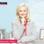 Amy Poehler as Leslie Knope in gray suit in front of Pawnee city seal