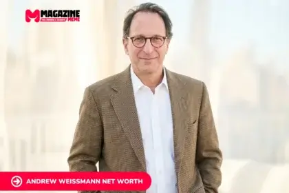 Andrew Weissmann portrait in brown tweed blazer, smiling indoors near sheer curtains