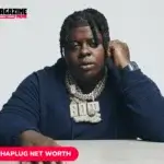 BigXthaPlug wearing a diamond "600" chain and watch, seated at a table