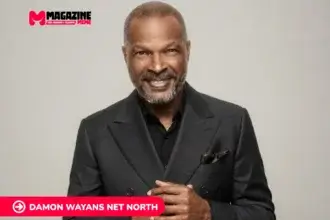 Damon Wayans smiling in a dark double-breasted suit against a gray backdrop