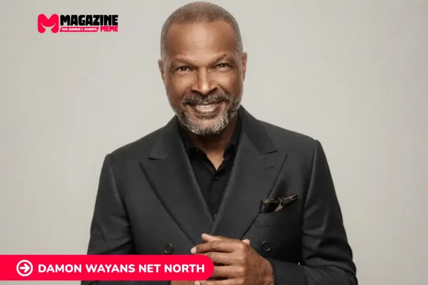 Damon Wayans smiling in a dark double-breasted suit against a gray backdrop