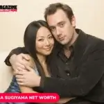 Emma Sugiyama and man in formal attire on a cream sofa, per image label