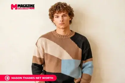 young man with curly hair in colorblock sweater against beige wall