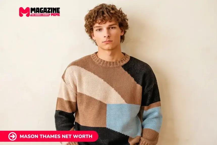young man with curly hair in colorblock sweater against beige wall