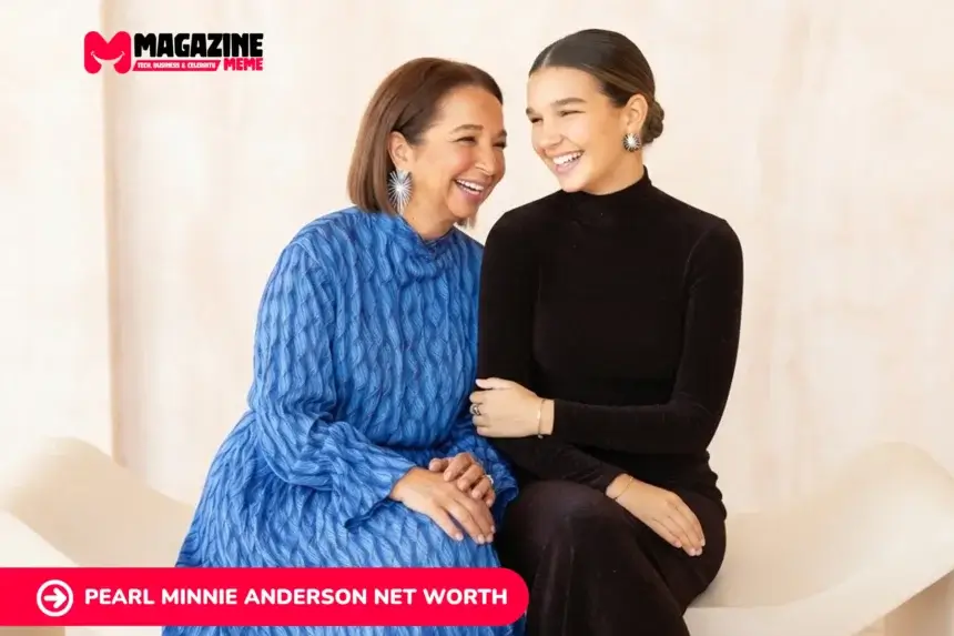 Two women share a laugh while seated together, one in a blue dress, one in black
