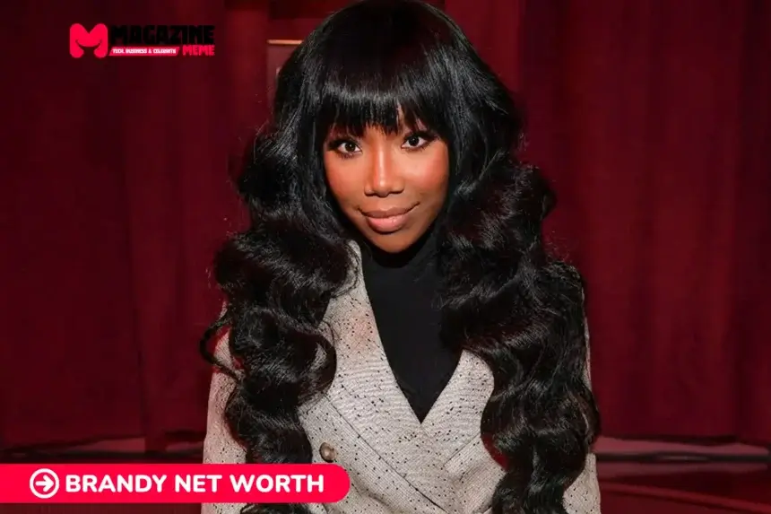 Brandy smiling in a beige blazer against a red curtain backdrop for the Brandy Net Worth article.