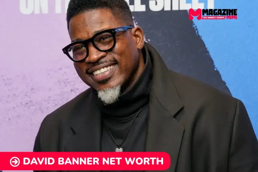 David Banner net worth portrait, smiling in glasses and black overcoat at event backdrop.