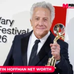 Dustin Hoffman net worth in a dark suit holding a glass and gold trophy at a film festival, for the Dustin Hoffman article.