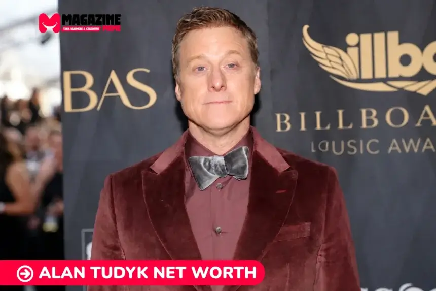 Alan Tudyk net worth in a maroon velvet suit at a red carpet event, pictured for the Alan Tudyk article.