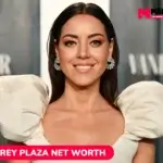 Aubrey Plaza net worth smiling in cream puff-sleeve gown for article portrait