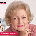 Betty White smiling in a pink turtleneck, close-up studio portrait for net worth article