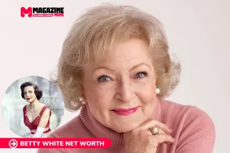Betty White smiling in a pink turtleneck, close-up studio portrait for net worth article