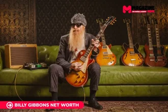 Billy Gibbons seated with a sunburst guitar and vintage amp, featured for the Billy Gibbons net worth article