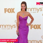 Brooke Burke in a strapless magenta gown on a red carpet, featured in the Brooke Burke net worth article.