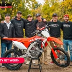 CboysTV group of eight in team sweatshirts beside a Honda dirt bike for the CboysTV net worth article