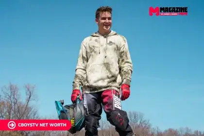 CboysTV photo of a smiling man in a tie-dye hoodie and motocross gear holding a helmet, for the Cboystv net worth article